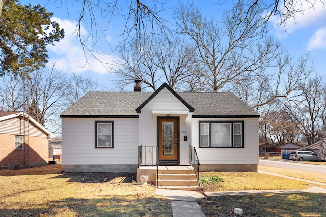 bungalow-style home featuring crawl space, a front lawn, roof with shingles, and a chimney