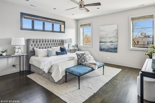 bedroom featuring visible vents, multiple windows, baseboards, and dark wood-type flooring