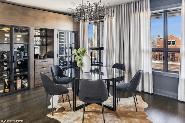 dining space with a notable chandelier, baseboards, and dark wood-style flooring