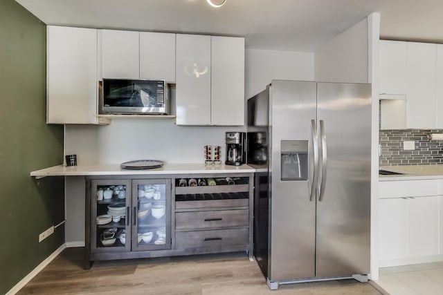 kitchen with white cabinets, light countertops, backsplash, and stainless steel fridge with ice dispenser