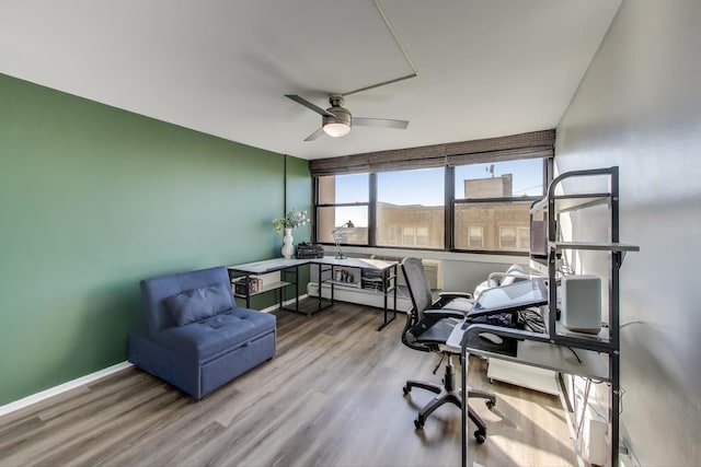 office featuring wood finished floors, a ceiling fan, and baseboards