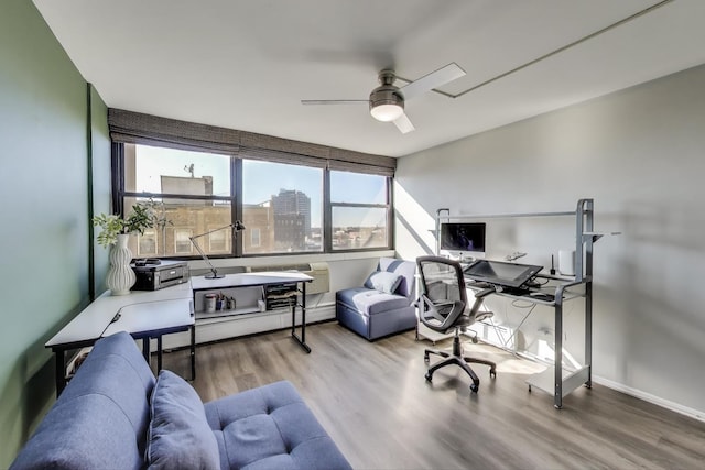 office space with a ceiling fan, baseboards, and wood finished floors