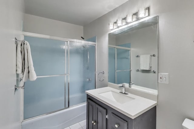 full bath featuring shower / bath combination with glass door, vanity, and tile patterned floors