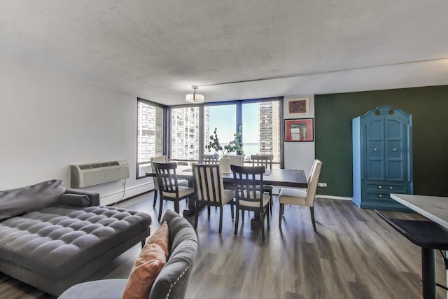 dining space with a textured ceiling, a wall mounted air conditioner, wood finished floors, and baseboards