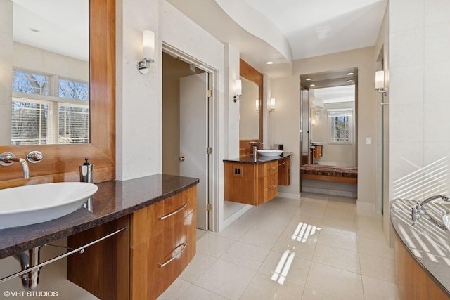 bathroom with tile patterned flooring, a sink, and a healthy amount of sunlight