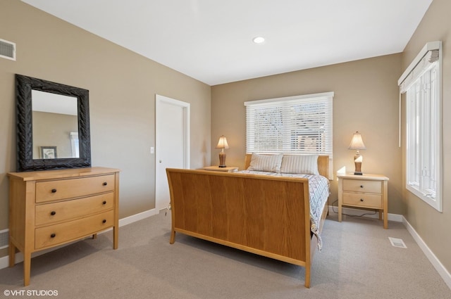 bedroom featuring light carpet, visible vents, and baseboards