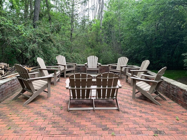 view of patio / terrace with an outdoor fire pit and a view of trees