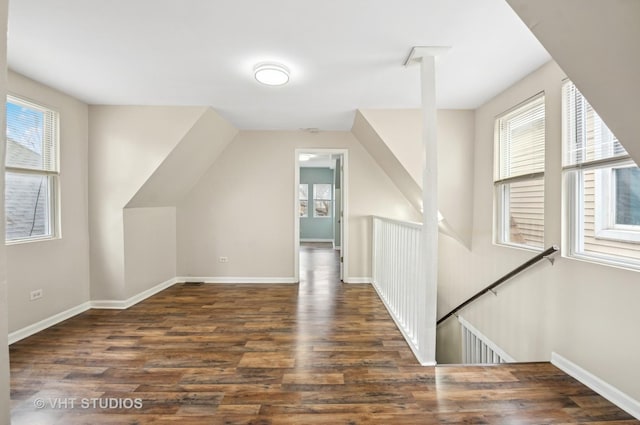 additional living space with vaulted ceiling, baseboards, and wood finished floors