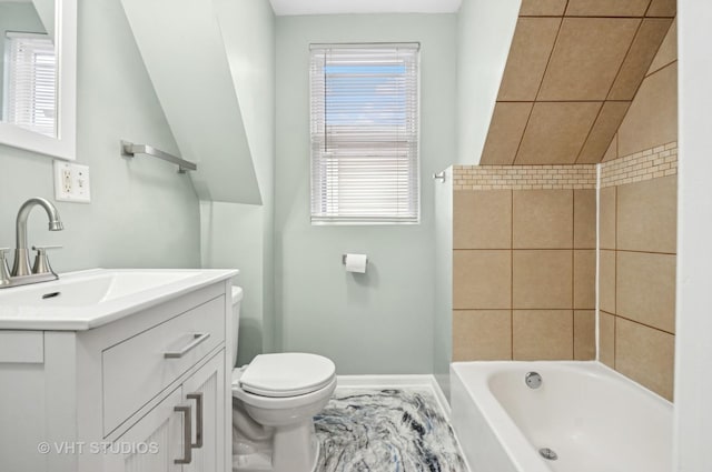 bathroom with vanity, toilet, and baseboards