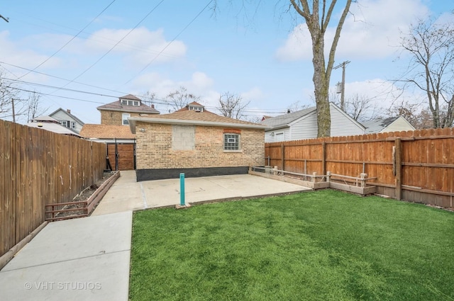 back of property with a patio, brick siding, a lawn, and a fenced backyard