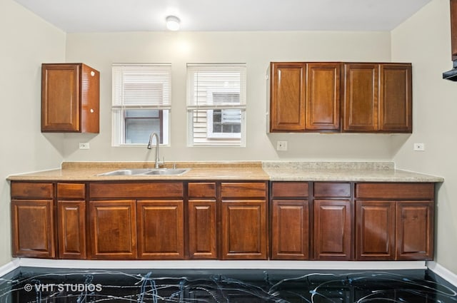 kitchen featuring light countertops, a sink, and baseboards