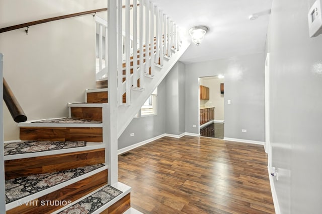 stairway featuring baseboards and wood finished floors