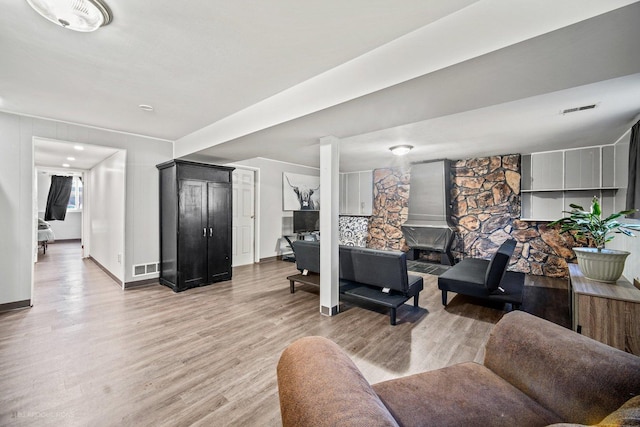 living room featuring light wood-style floors, baseboards, and visible vents