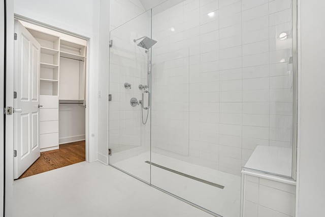 bathroom featuring a stall shower and a walk in closet