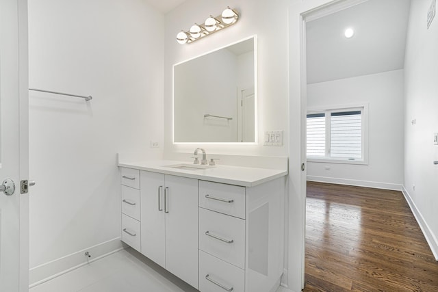 bathroom with wood finished floors, vanity, and baseboards