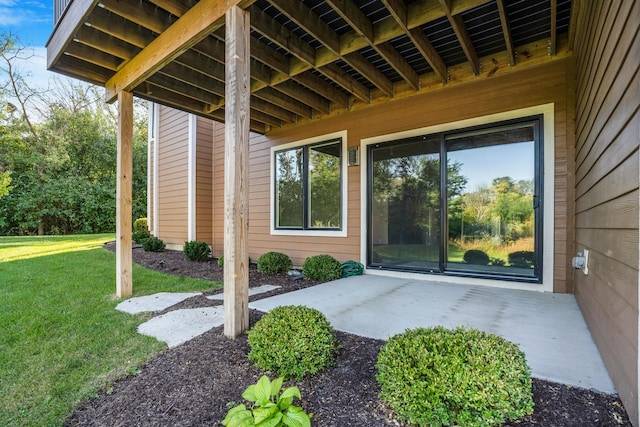 doorway to property with a lawn and a patio area