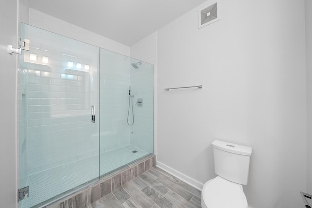 bathroom featuring a stall shower, baseboards, visible vents, and toilet