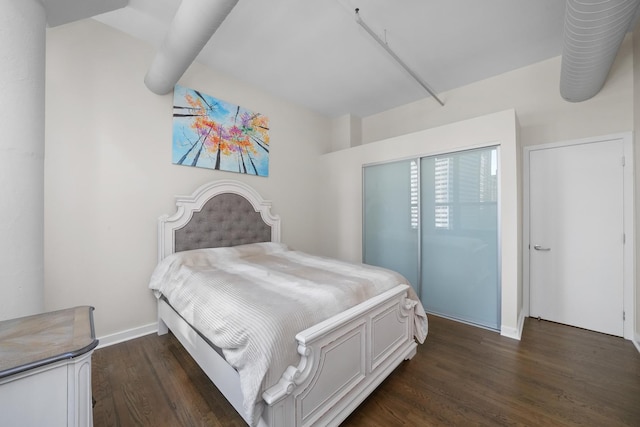 bedroom featuring dark wood-style flooring and baseboards