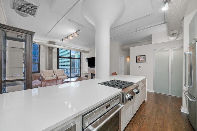 kitchen with visible vents, open floor plan, light countertops, appliances with stainless steel finishes, and dark wood finished floors