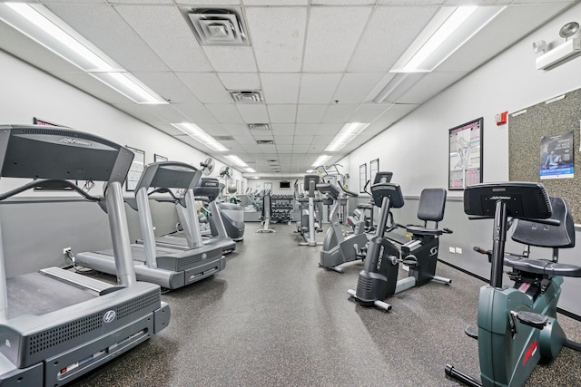 gym with baseboards, visible vents, and a drop ceiling