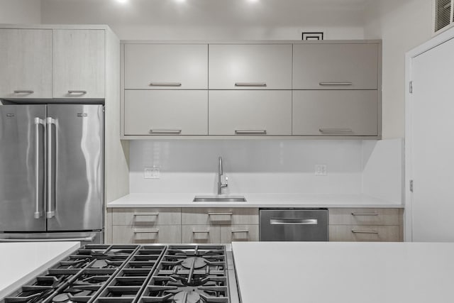 kitchen featuring stainless steel appliances, light countertops, a sink, and modern cabinets