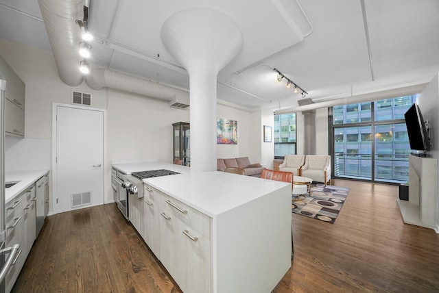 kitchen with a peninsula, visible vents, light countertops, and dark wood-style flooring