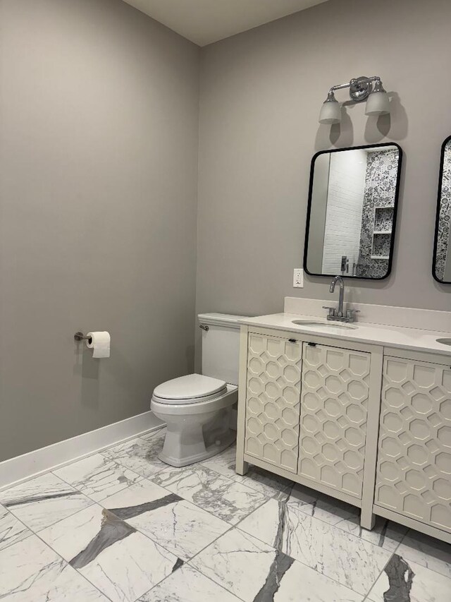 bathroom featuring marble finish floor, toilet, vanity, and baseboards