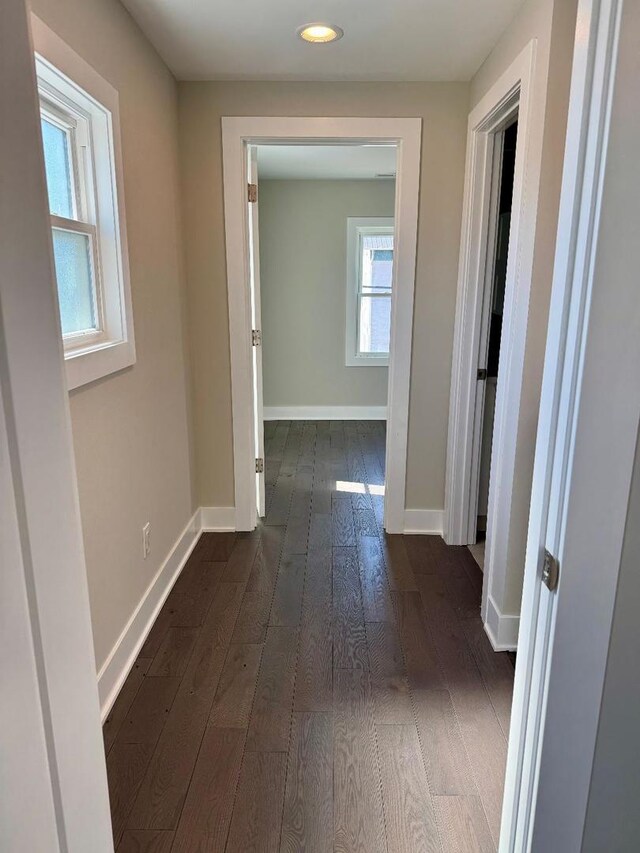 hall with dark wood-style floors and baseboards