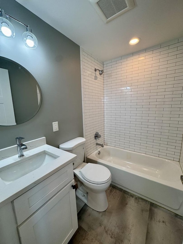 bathroom with visible vents, toilet, wood finished floors, shower / washtub combination, and vanity