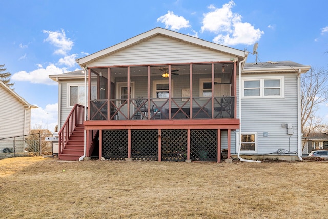 back of property with a sunroom, a yard, stairway, and fence