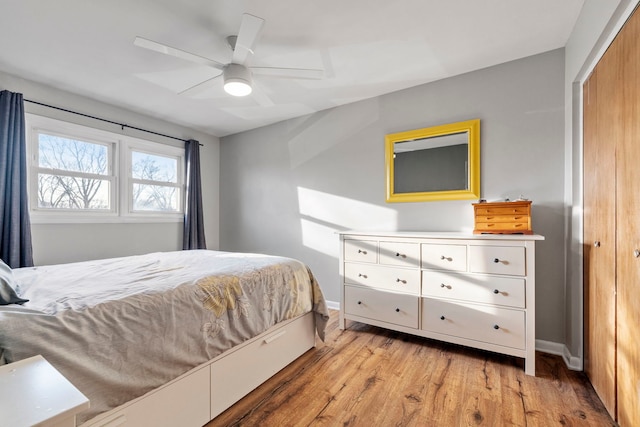 bedroom featuring light wood-style flooring, baseboards, and a ceiling fan