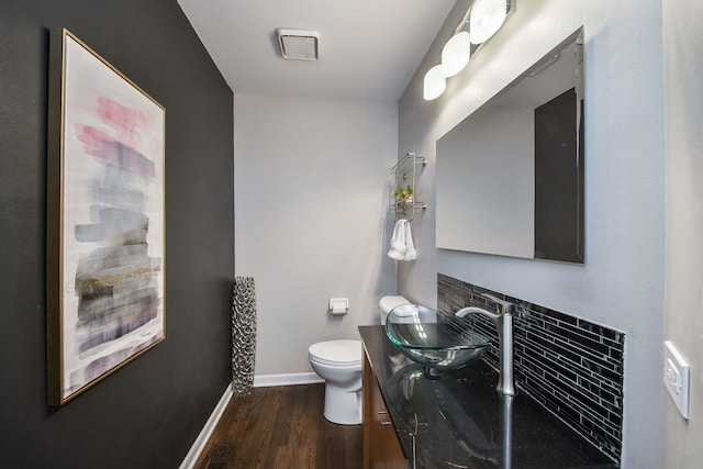 bathroom with baseboards, vanity, toilet, and wood finished floors