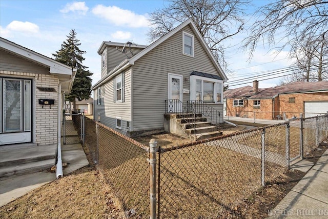 view of front of property featuring brick siding, fence private yard, and a gate