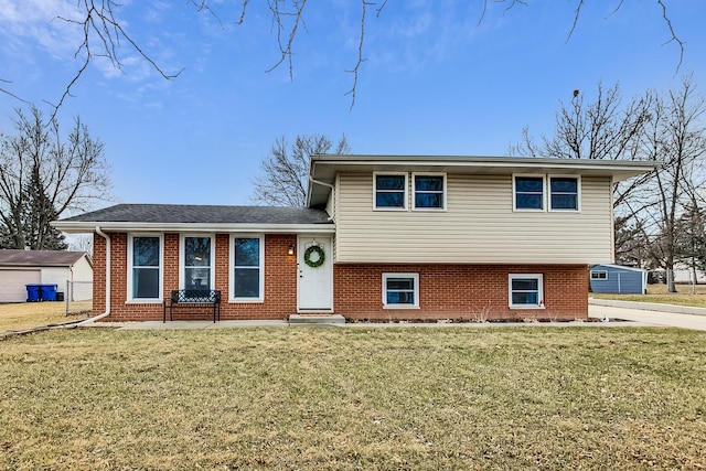 split level home featuring a front lawn and brick siding