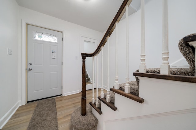 entrance foyer with stairs, light wood-style flooring, and baseboards