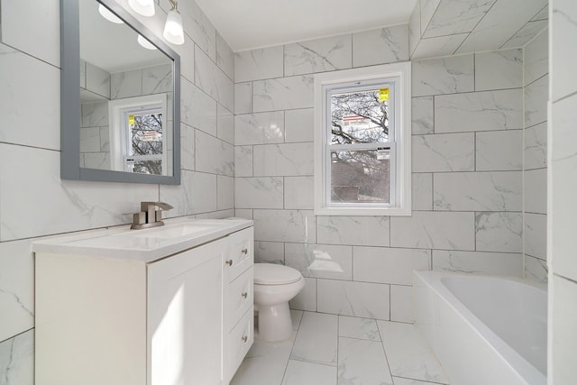 full bathroom with toilet, marble finish floor, a washtub, tile walls, and vanity