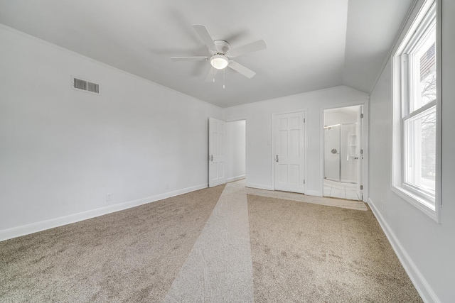 unfurnished bedroom featuring multiple windows, baseboards, visible vents, and light carpet