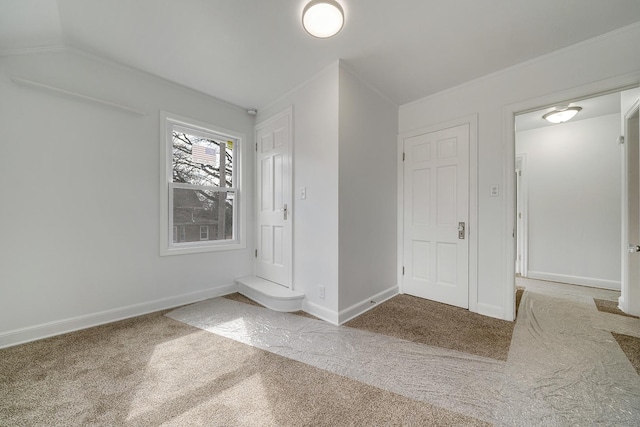 interior space with vaulted ceiling, baseboards, and ornamental molding