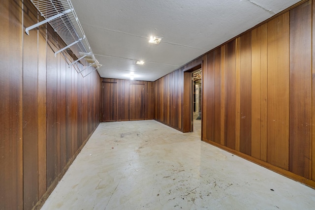 finished basement featuring wood walls