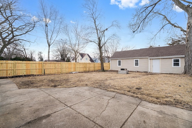 rear view of property featuring a patio area, a fenced backyard, and roof with shingles