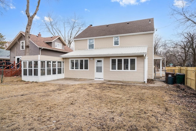 rear view of property featuring a patio area, fence, and a sunroom