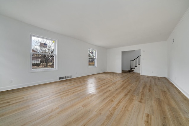 spare room with visible vents, baseboards, stairs, and light wood finished floors