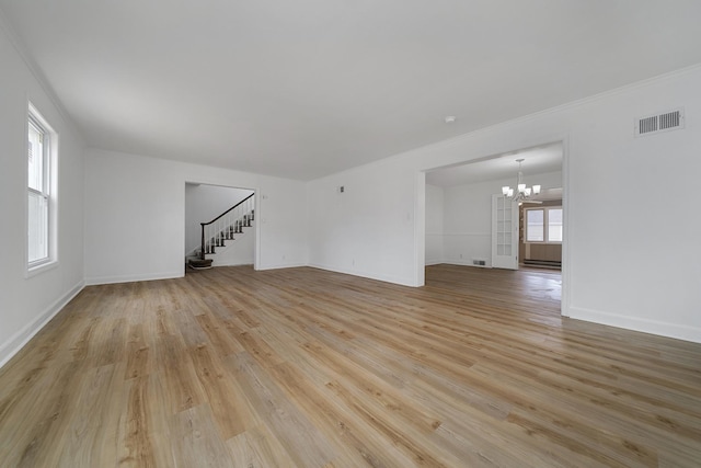 unfurnished living room with light wood-type flooring, visible vents, a notable chandelier, stairway, and baseboards