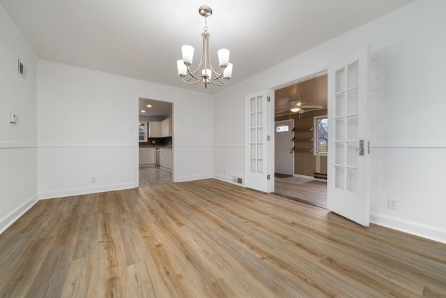 unfurnished room with visible vents, light wood finished floors, baseboards, french doors, and crown molding