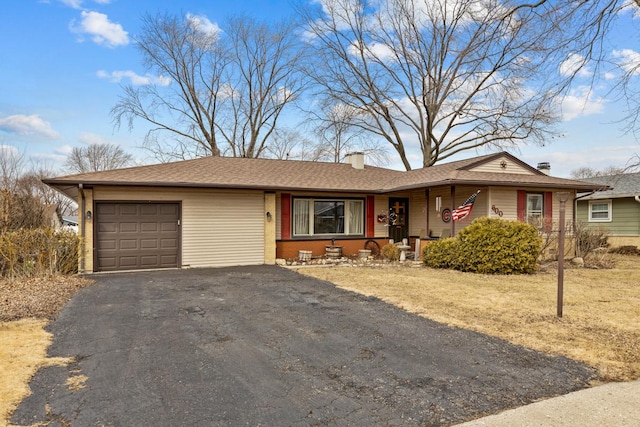 single story home featuring a garage, a chimney, and aphalt driveway