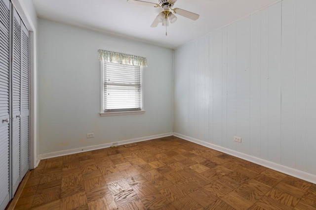 unfurnished bedroom with a closet, a ceiling fan, and baseboards