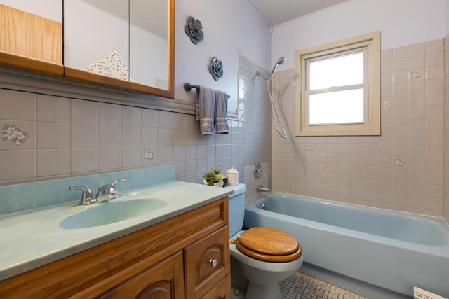 bathroom with tile patterned flooring, toilet, bathtub / shower combination, vanity, and tile walls