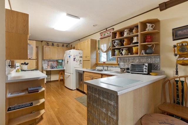 kitchen with a toaster, a peninsula, freestanding refrigerator, dishwasher, and open shelves