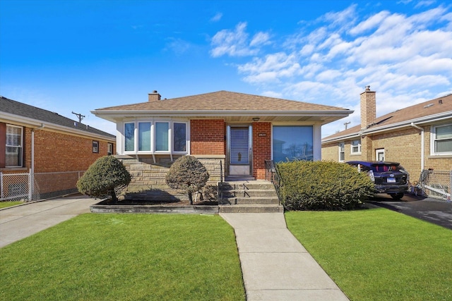 bungalow with stone siding, roof with shingles, fence, a front yard, and brick siding