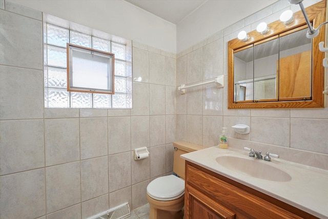 bathroom featuring tasteful backsplash, tile walls, toilet, and vanity